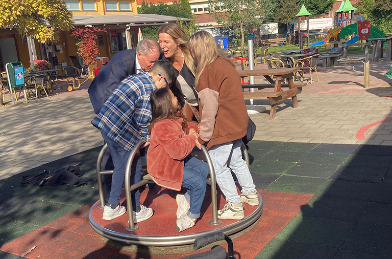 Kamerleden en kinderambassadeurs op een speeltoestel in een speeltuin in Leiden