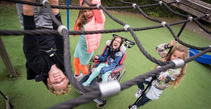 Kinderen met en zonder beperking spelen samen in op een speelplek