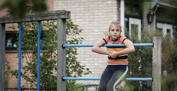 Sijtje speelt alleen in de speeltuin op het klimrek