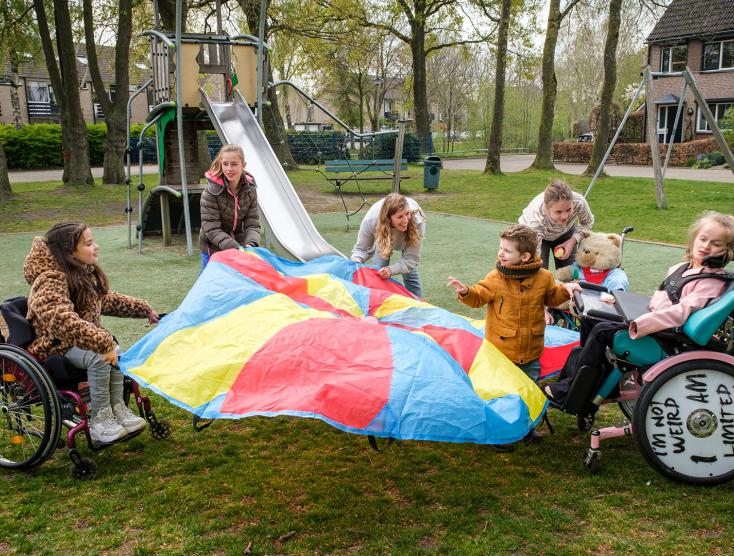 Kinderen met een beperking aan het spelen met een groot doek | Samenspeeldagen
